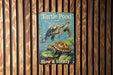 a picture of a turtle pond sign on a wooden wall