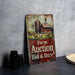 a farm auction sign sitting next to a pair of binoculars
