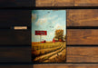 a painting of a farm scene on a wooden bench