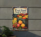 a fruit stand sign hanging on the side of a building
