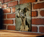 a picture of a dog hanging on a brick wall