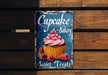 a sign on a wooden wall that says cupcake bakery sweet treats