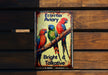 a metal sign with three colorful birds on it
