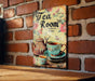 a picture of a tea room sign on a brick wall