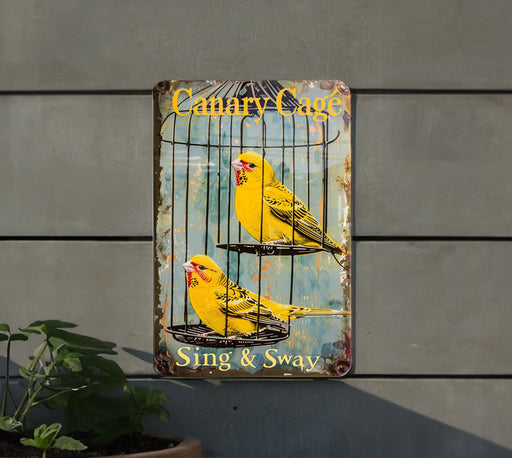 a yellow bird sitting on top of a cage next to a plant