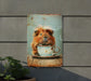 a metal sign with a picture of a guinea pig holding a cup of coffee