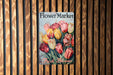 a flower market sign hanging on a wooden wall