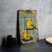 a yellow bird sits in a cage on a table