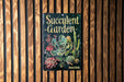 a book about succulent garden on a wooden wall