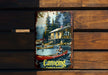 a picture of a canoers paddling in front of a cabin