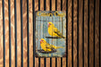 a yellow bird sitting on top of a cage