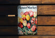 a flower market book sitting on top of a wooden bench