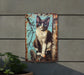 a picture of a cat is hanging on a wall