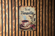 a tea and tranquilly sign hanging on a wooden wall