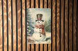 a picture of a snowman on a wooden wall