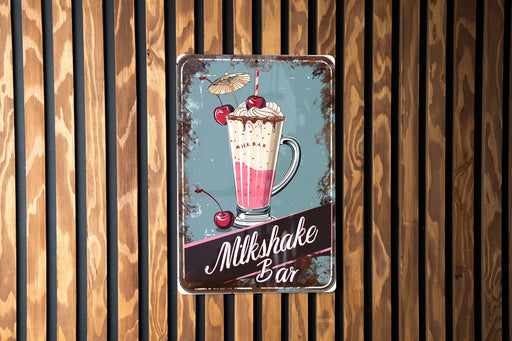 a metal sign on a wooden wall advertising milkshake bar