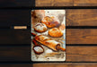 a painting of bread and other pastries on a wooden surface