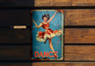 a tin sign with a woman dancing on it