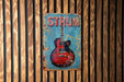 a red and blue guitar on a wooden wall