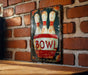 a picture of a bowling pin on a brick wall