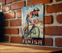 a painting of a man riding a bike on a brick wall