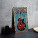 a sign with a guitar on it sitting on a table