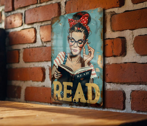 a picture of a woman reading a book on a brick wall