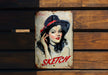 a painting of a woman with a hat on a wooden bench