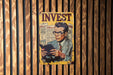 a poster of a man reading a book on a wooden wall