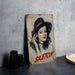 a painting of a woman with a hat on a table