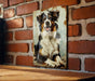 a picture of a dog hanging on a brick wall