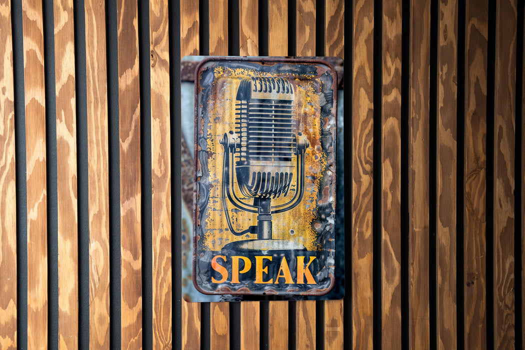 a sign on a wooden wall that says speak