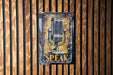 a sign on a wooden wall that says speak