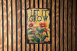 a sign on a wooden wall that says let it grow