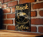 a black coffee sign on a brick wall