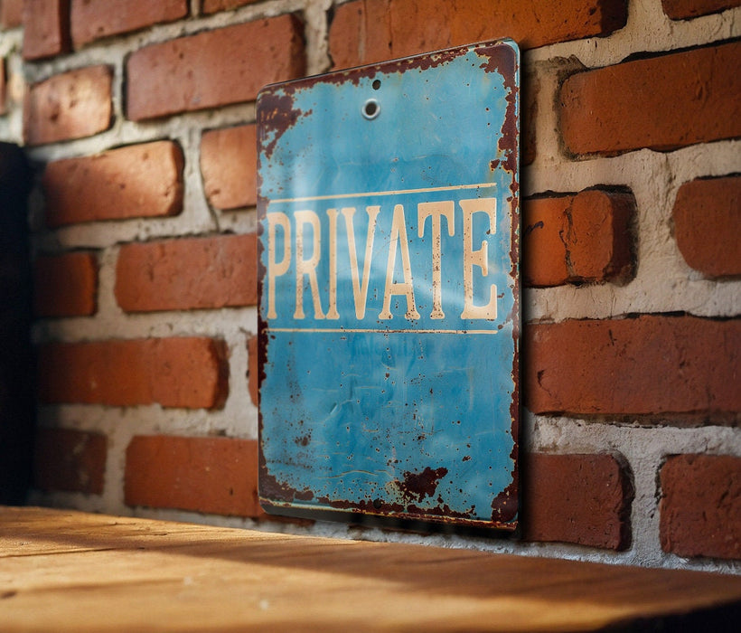 a blue private sign on a brick wall