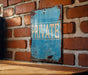a blue private sign on a brick wall