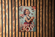 a painting of a girl holding a flower on a wooden wall