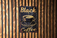 a black coffee sign on a wooden wall