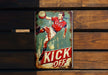 a metal sign that says kick off with a soccer player kicking a ball