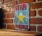 a sign on a brick wall that says staff needed