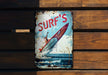 a sign on a wooden wall that says surf's