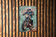 a painting of a man riding a motorcycle on a wooden wall