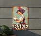 a metal sign with a woman holding a plate of cake