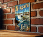 a picture of niagara falls hanging on a brick wall