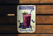 a blueberry smoothie sign hanging on a wooden wall