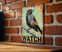 a picture of a bird on a sign on a brick wall