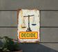 a rusty sign with a scale and the word decide on it