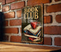 a book club sign on a brick wall