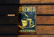 a metal sign with a cup of coffee on it